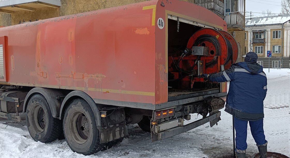 Каналопромывочная машина и работник прочищают засор в канализационной системе в Нижнем Новгороде